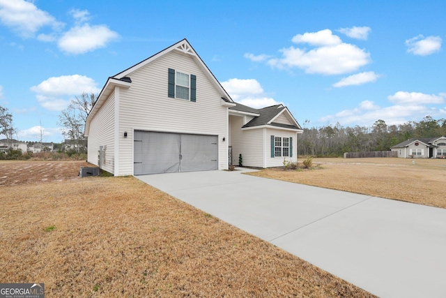 view of property featuring cooling unit, a garage, and a front yard