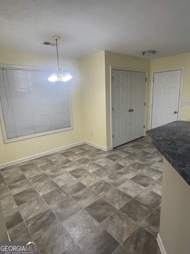 unfurnished dining area featuring a notable chandelier