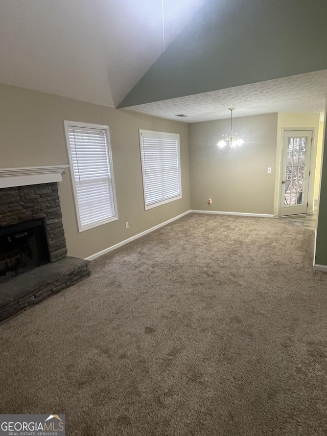 unfurnished living room featuring vaulted ceiling, carpet flooring, a textured ceiling, a fireplace, and a chandelier