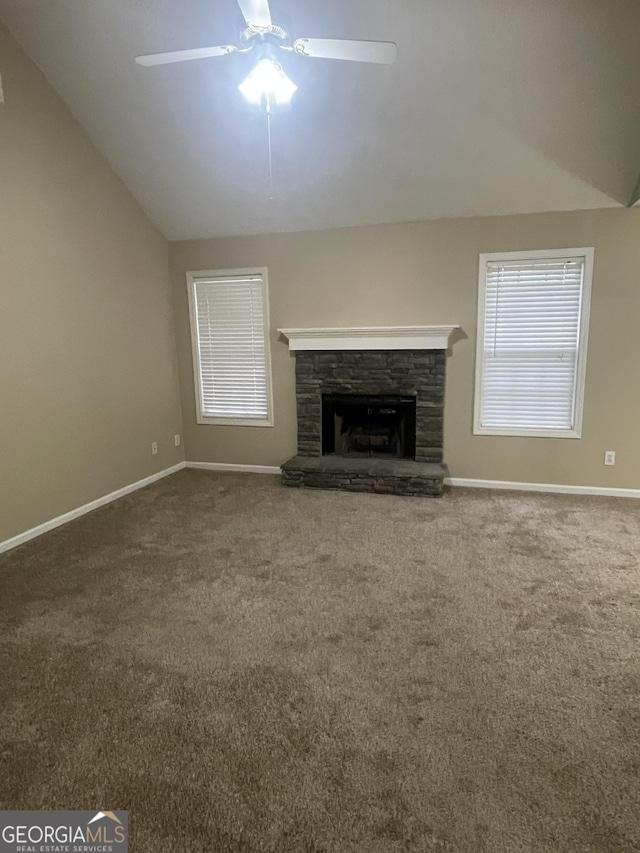 unfurnished living room featuring ceiling fan, a fireplace, carpet, and vaulted ceiling