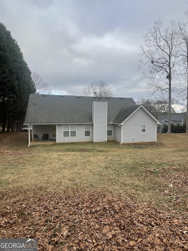 rear view of property with a yard