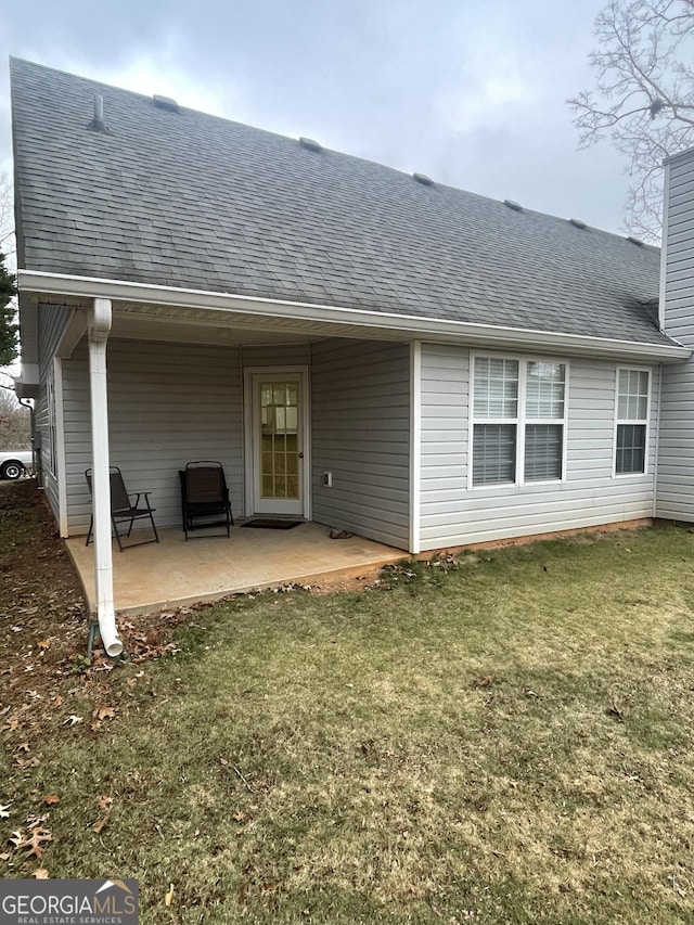 back of property featuring a lawn and a patio area