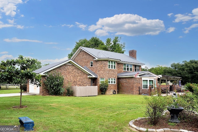 back of house with brick siding, a lawn, a chimney, a garage, and a pergola