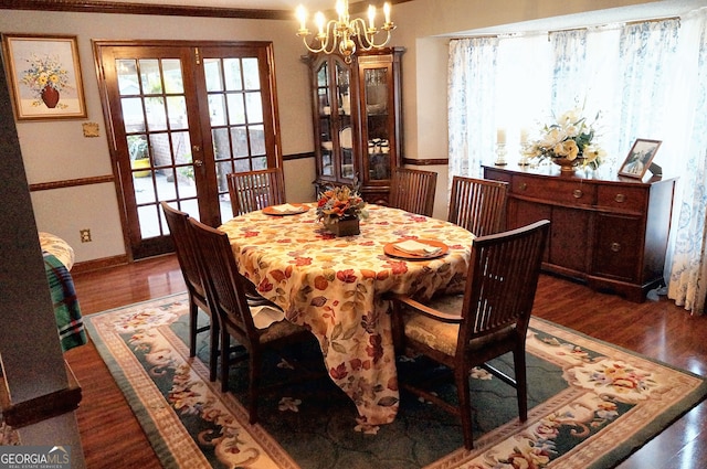 dining space featuring dark hardwood / wood-style flooring, a healthy amount of sunlight, and an inviting chandelier