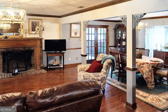 living area with visible vents, ornamental molding, a fireplace, french doors, and wood finished floors