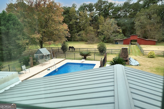 view of swimming pool with a fenced in pool, an outdoor structure, a yard, and fence