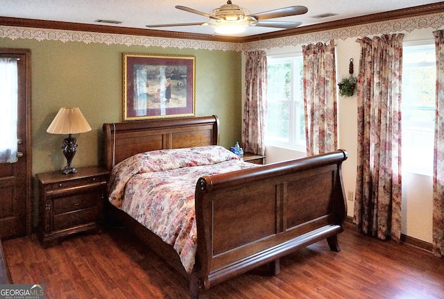 bedroom featuring ceiling fan, dark hardwood / wood-style floors, and crown molding