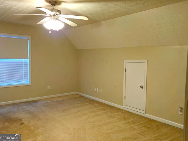 bonus room with a textured ceiling, ceiling fan, light colored carpet, and vaulted ceiling