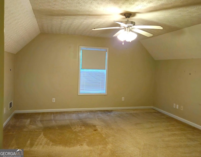 bonus room with a textured ceiling, light colored carpet, and lofted ceiling