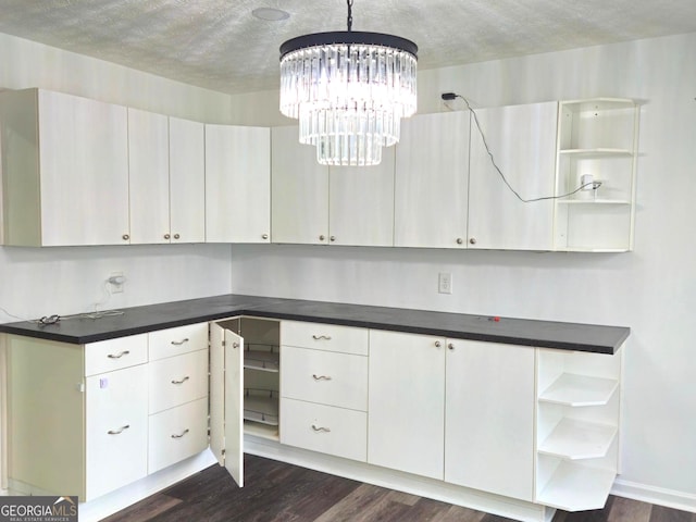 kitchen with white cabinets, decorative light fixtures, dark wood-type flooring, and a chandelier