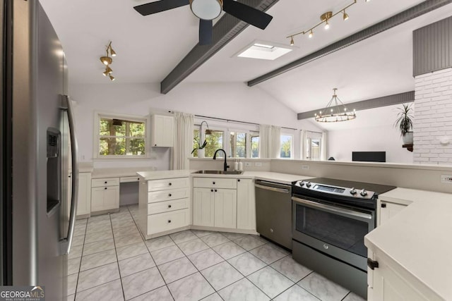 kitchen featuring lofted ceiling with skylight, sink, decorative light fixtures, and appliances with stainless steel finishes