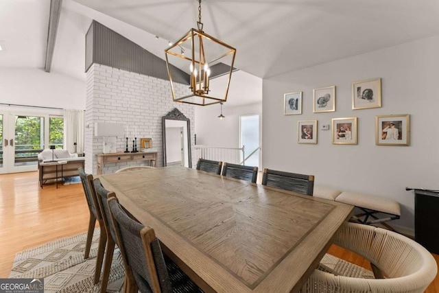 dining room with a chandelier, lofted ceiling with beams, and hardwood / wood-style flooring