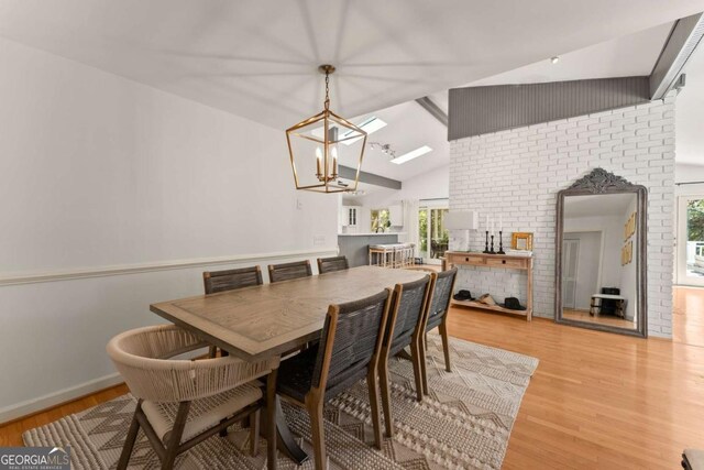 dining room with light wood-type flooring, lofted ceiling, and a notable chandelier