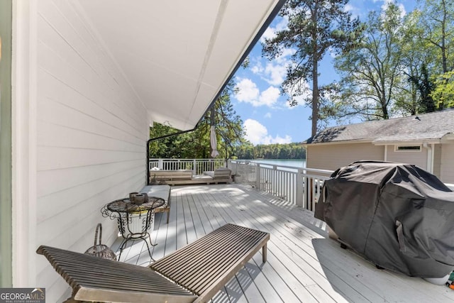 wooden deck with a water view and area for grilling