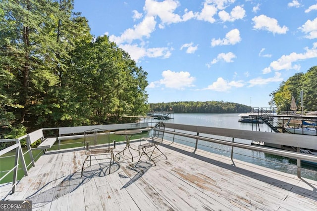 wooden terrace featuring a water view and a dock