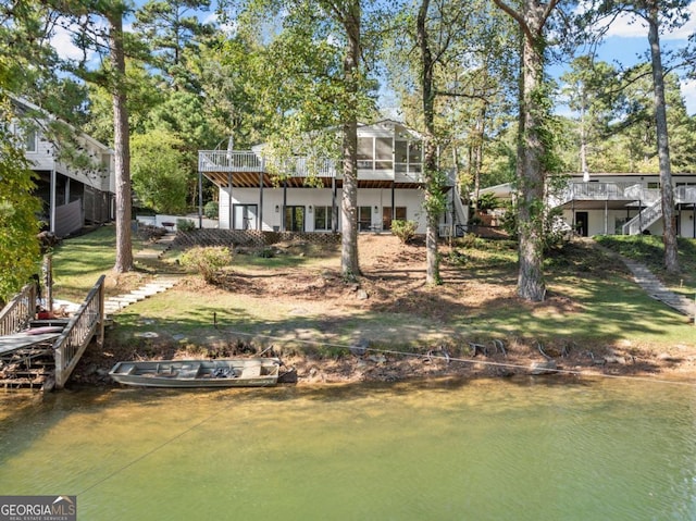 rear view of house with a deck with water view