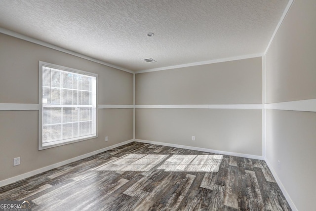 empty room with dark hardwood / wood-style floors and a textured ceiling