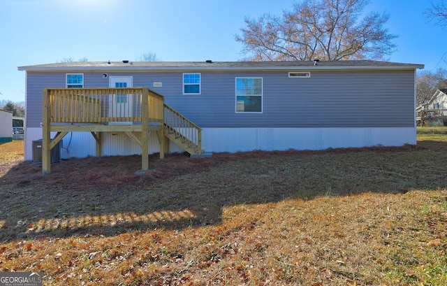 back of property with a wooden deck and a yard