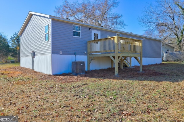 rear view of property with central air condition unit, a wooden deck, and a yard