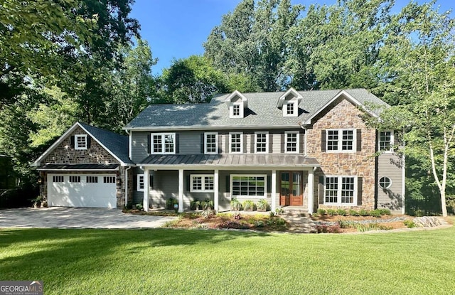 view of front facade with covered porch, a garage, and a front yard