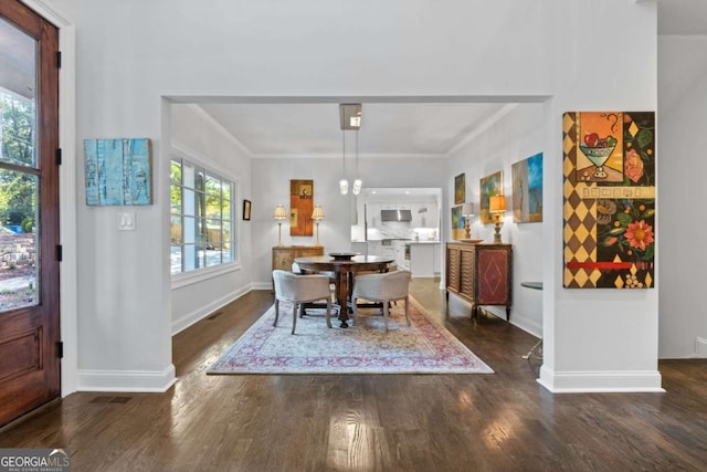 dining space with crown molding, baseboards, and wood finished floors