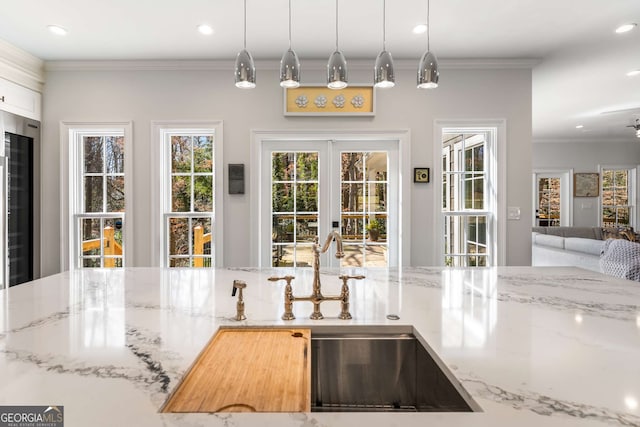 kitchen featuring ornamental molding, a sink, recessed lighting, french doors, and light stone countertops