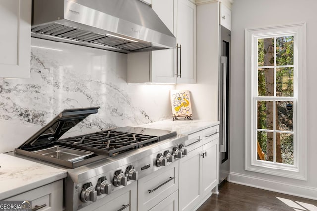 kitchen featuring decorative backsplash, range hood, white cabinetry, and stainless steel gas cooktop