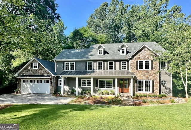 view of front of home featuring a porch, a garage, and a front lawn