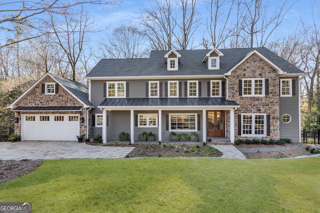 view of front of house with an attached garage, a front lawn, stone siding, decorative driveway, and metal roof