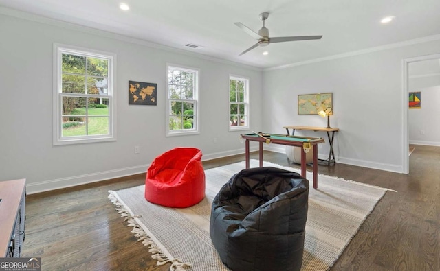 living area featuring dark hardwood / wood-style floors, ceiling fan, and crown molding