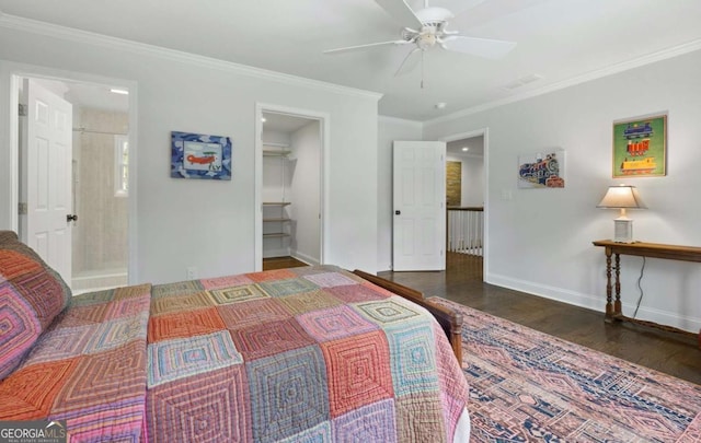 bedroom featuring wood finished floors, baseboards, ensuite bath, ornamental molding, and a spacious closet