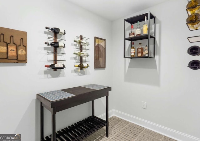 wine cellar featuring baseboards and a bar