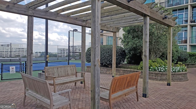 view of patio / terrace with a pergola and tennis court