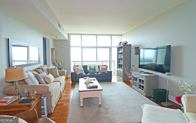 living room featuring wood-type flooring and a wall of windows