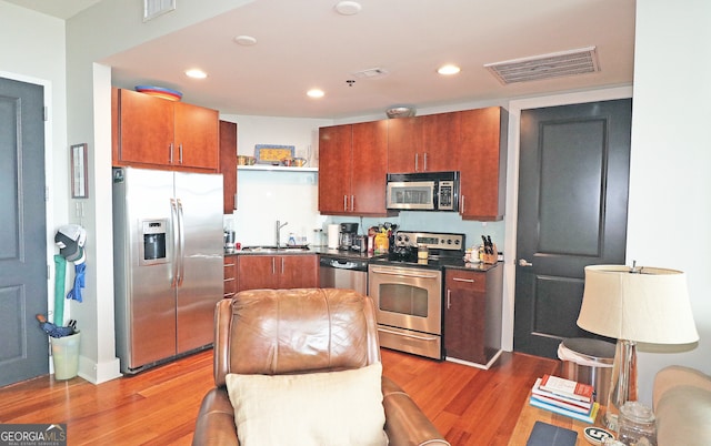 kitchen featuring wood-type flooring, sink, and appliances with stainless steel finishes