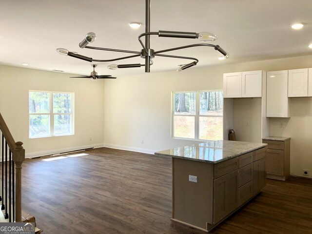 unfurnished living room featuring dark hardwood / wood-style flooring and ceiling fan