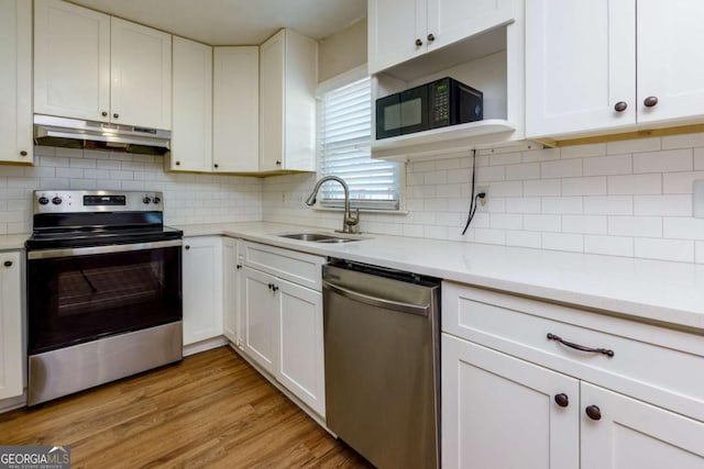 kitchen featuring sink, white cabinets, stainless steel appliances, and light wood-type flooring