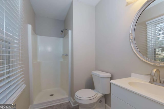 bathroom with a shower, vanity, and toilet