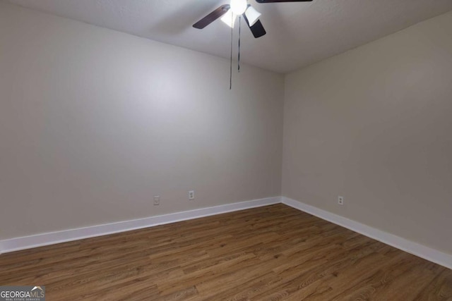 spare room with dark hardwood / wood-style flooring and ceiling fan