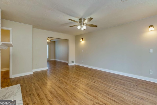 spare room featuring a textured ceiling, light hardwood / wood-style flooring, and ceiling fan