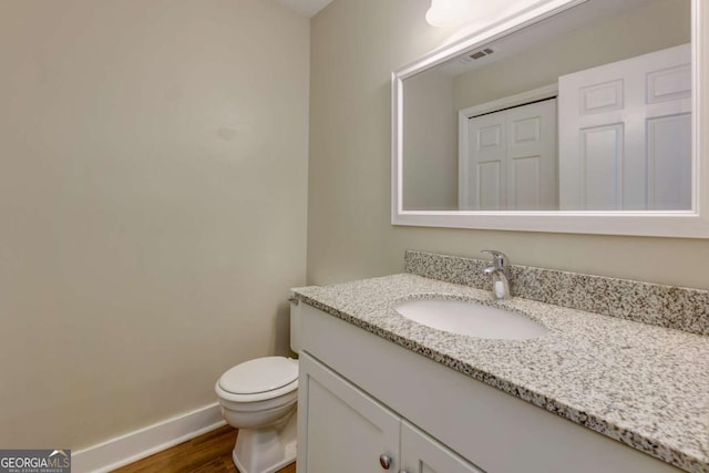 bathroom featuring vanity, hardwood / wood-style flooring, and toilet