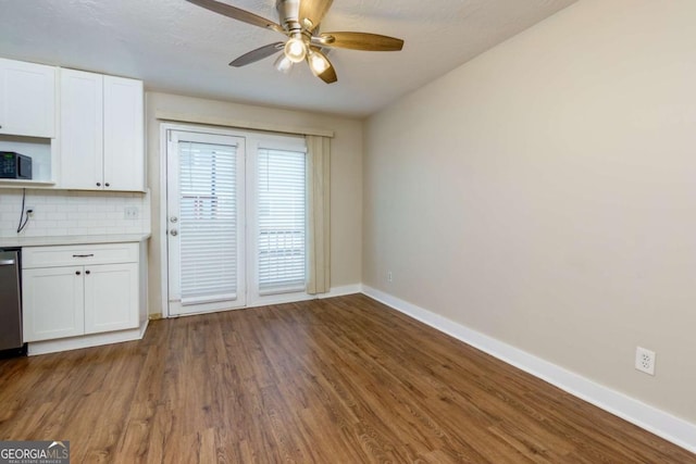 kitchen featuring tasteful backsplash, ceiling fan, hardwood / wood-style flooring, dishwasher, and white cabinets