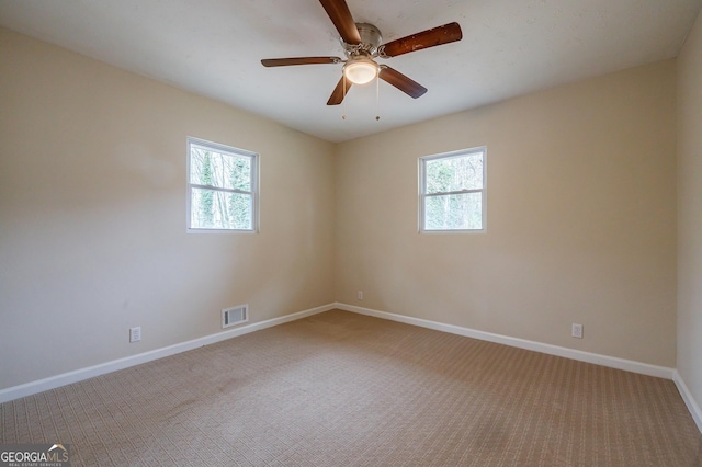 empty room with carpet floors, ceiling fan, and a healthy amount of sunlight