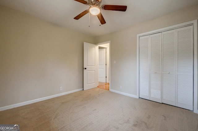 unfurnished bedroom featuring light carpet, a closet, and ceiling fan