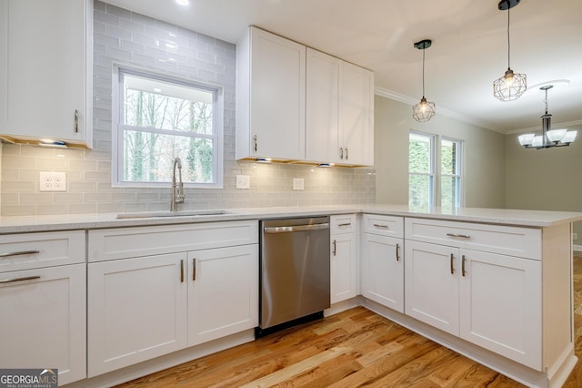 kitchen featuring dishwasher, white cabinets, sink, hanging light fixtures, and kitchen peninsula