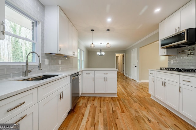 kitchen featuring tasteful backsplash, white cabinetry, sink, and stainless steel appliances