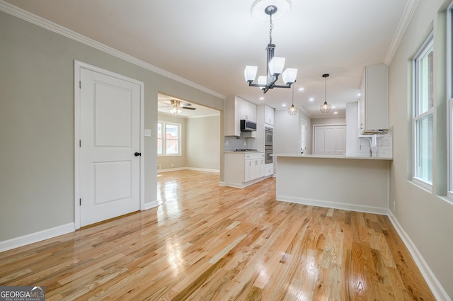 unfurnished living room featuring ornamental molding, ceiling fan with notable chandelier, and light wood-type flooring