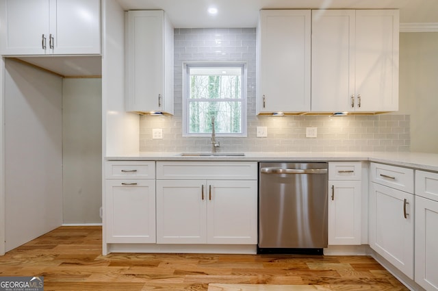 kitchen featuring tasteful backsplash, sink, dishwasher, light hardwood / wood-style floors, and white cabinetry