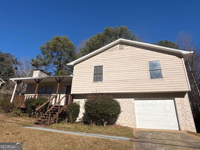 view of side of home featuring covered porch and a garage