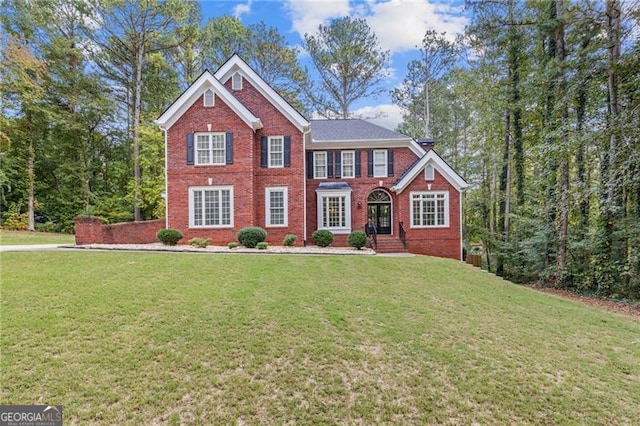 colonial home featuring brick siding and a front lawn